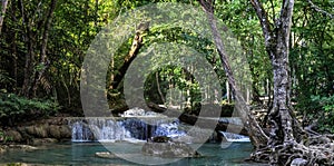 Panorama of a beautiful waterfall in the dense forest of Erawan National park in Thailand