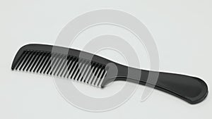 Panorama of a black plastic comb on a white background.
