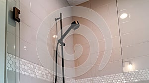 Panorama Black round shower head on tile wall of shower stall with hinged glass door