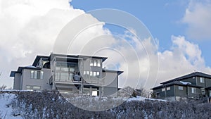 Panorama Blue sky and puffy clouds over homes on an inceredible mountain setting in winter