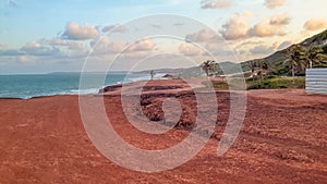 Panorama of brazilian beach with red dunes bathed by ocean waves photo