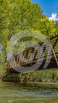 Panorama Bridge with metal guardrails over the glistening water at Ogden River Parkway