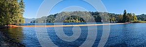 Panorama of the bright orange boom and the dam at the Merwin Reservoir near Ariel, Washington, USA