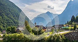 Panorama with buildings, main Road and Parish Church inside Mountain Landscape of Village Log pod Mangartom. Bovec, Slovenia,