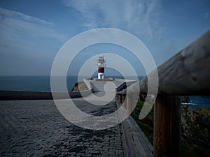 Panorama of Cabo Ortegal lighthouse on steep rocky cliff atlantic ocean bay of biscay Carino Cape Galicia Spain photo