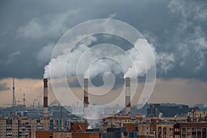 Panorama of the city with a gray cloudy sky and Smoking production pipes.