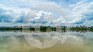 Panorama of city reflection in water under clouds during daytime