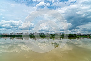 Panorama of city reflection in water under clouds during daytime