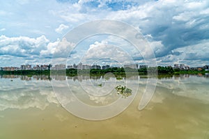 Panorama of city reflection in water under clouds during daytime