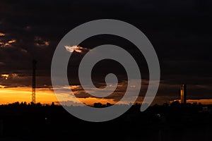 Panorama Cityscape at sunset with large river at foreground and strom clouds at background in Thailand