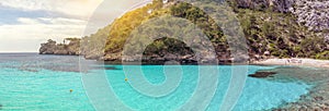 A panorama of clear blue waters and a beach in a mountain valley