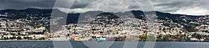 Panorama of Coastline. Funchal, Madeira with high cliffs along the Atlantic Ocean. Dramatic sky.