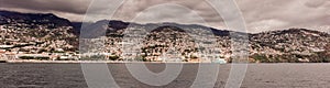 Panorama of Coastline. Funchal, Madeira with high cliffs along the Atlantic Ocean. Dramatic sky.