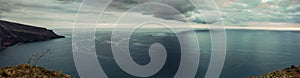 Panorama of Coastline. Madeira with high cliffs along the Atlantic Ocean. Dramatic sky.