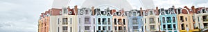 Panorama colorful shophouses painted upscale townhome duplex with decorated balcony flower decoration, upscale row of multistory