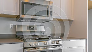 Panorama Cooking range and wall mounted microwave inside a modern kitchen