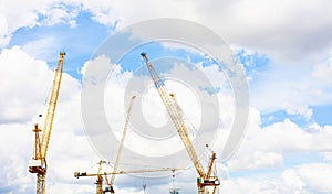 Panorama of crane construction site on background of blue sky and cloud