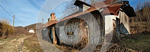 Creepy old house on a dusty road on a sunny day.