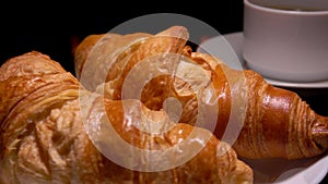 Panorama of croissants lying next to a coffee cup