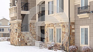 Panorama crop Residential apartment building facade with snow covered yard in winter