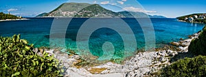 Panorama of crystal clear transparent blue turquoise teal Mediterranean seascape in Fiskardo town. Kefalonia, Ionian