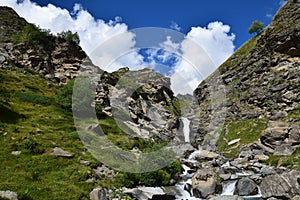 Panorama delle Alpi, Cascata con Cielo Blu e Nuvole Bianche