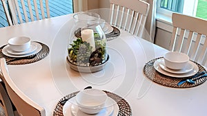 Panorama Dinner table setting with tableware on placemats arranged around a centerpiece