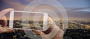 Panorama Double exposure of hands holding a mobile phone and taking a picture of cityscape Los Angeles at night