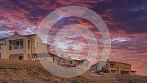 Panorama Dramatic sunset with clouds Fenced residential buildings on top of a hill at San Diego, Cali