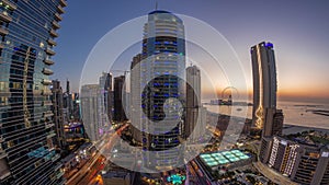 Panorama of the Dubai Marina and JBR area and the famous Ferris Wheel aerial day to night timelapse