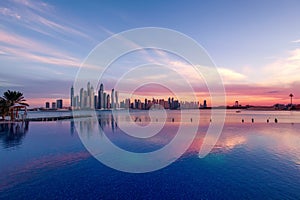 Panorama of Dubai Marina at sunset with a swimming pool in front