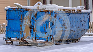 Panorama Dumpster on the snow covered ground against houses in Daybreak Utah