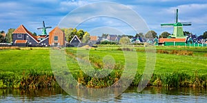 Panorama of a Dutch village with windmills, green houses pastures and meadows. Agricultural landscape. Tourism. Holland,