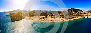 Panorama of the famous resort beach tsampika with rows of sunbeds and umbrellas, view of the mountains, the island from