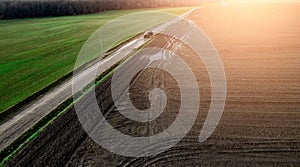 Panorama of a farmer`s field top view. The tractor makes organic fertilizers