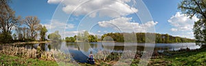 Panorama of father and son fishing on a picturesque lake