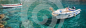 Panorama of fishing boats on clear water in Crete Greece