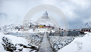 Panorama of fishing village in snow steep mountain with wooden b