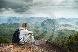 Panorama of fit and active young man resting after hike and enjoying view. Tab Kak Hang Nak Hill Nature Trail. Thailand. photo