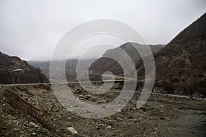 Panorama of the foggy winter landscape in the mountains with snow and rocks, Azerbaijan, Lahic, Big Caucasus