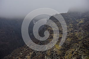 Panorama of the foggy winter landscape in the mountains with snow and rocks, Azerbaijan, Lahic, Big Caucasus