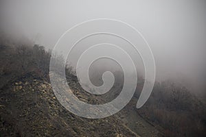 Panorama of the foggy winter landscape in the mountains with snow and rocks, Azerbaijan, Lahic, Big Caucasus