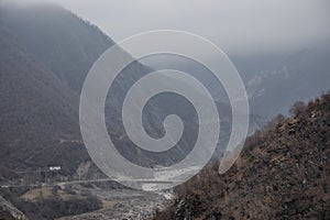 Panorama of the foggy winter landscape in the mountains with snow and rocks, Azerbaijan, Lahic, Big Caucasus