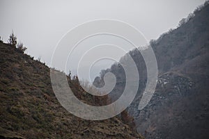 Panorama of the foggy winter landscape in the mountains with snow and rocks, Azerbaijan, Lahic, Big Caucasus