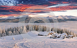 Panorama of foggy winter sunrise in the mountains