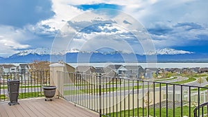 Panorama frame Balcony with wooden floor and metal railing overlooking lake and mountain