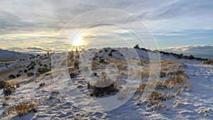 Panorama frame Bright sun in the cloudy sky over snowy hills and mountain in scenic Utah Valley