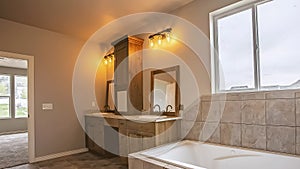 Panorama frame Built in bathtub in front the window of a bathroom with tiled floor and wall