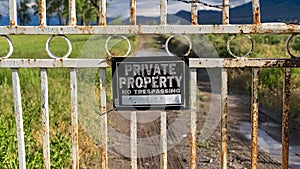 Panorama frame Close up of a locked gate at a private property with view of lake and mountain