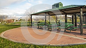 Panorama frame Covered picnic area on a scenic park under cloudy blue sky